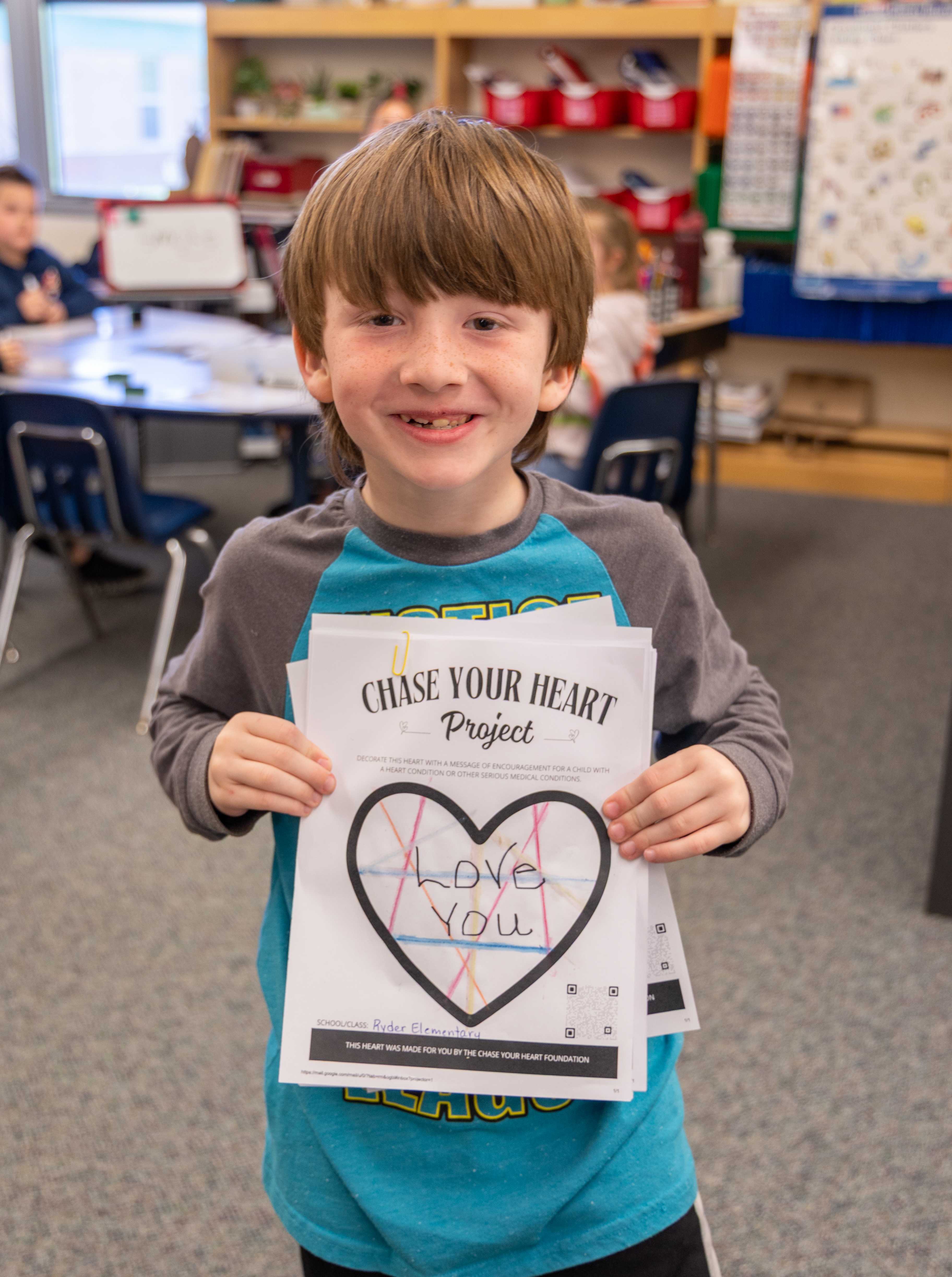 A student holds a designed heart that says "Love You".